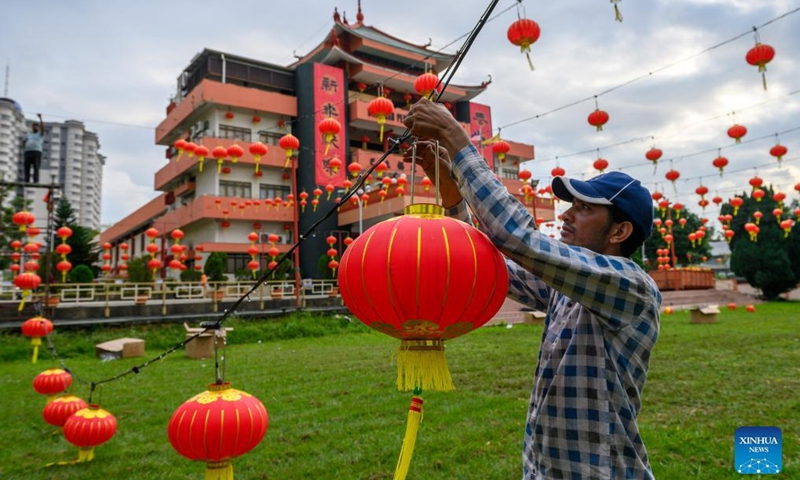 A man hangs lanterns for the upcoming Spring Festival, or the Chinese Lunar New Year, in Klang of Selangor states, Malaysia, Jan. 16, 2022.Photo:Xinhua