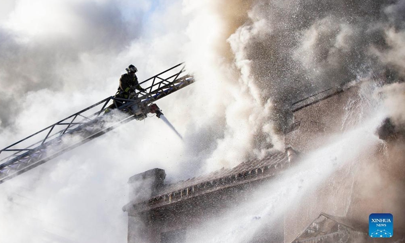 A firefighter works to extinguish a fire burning at an apartment building in Toronto, Canada, on Jan. 15, 2022.Photo:Xinhua